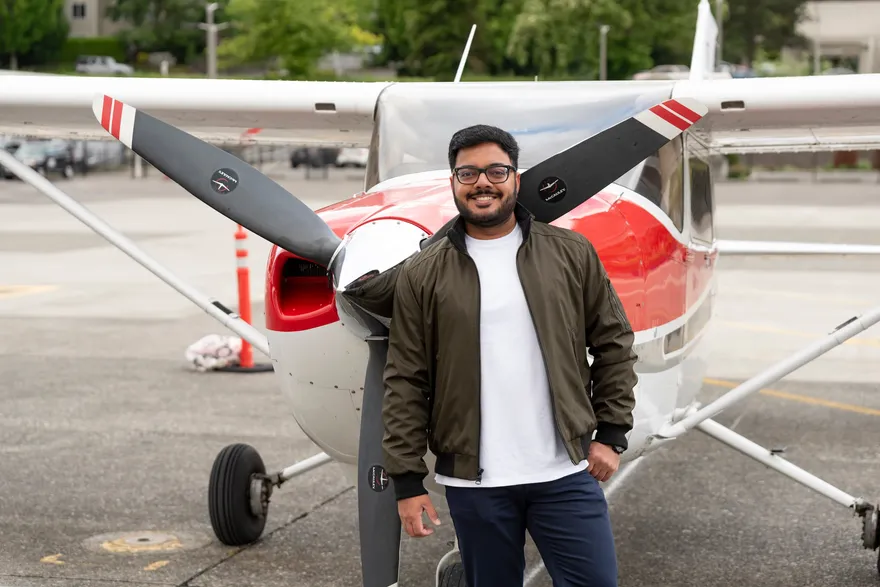 Alok Upadhyay standing in front of a Cessna aircraft and its propeller